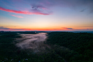 Aerial view of forest and fog at sunset
