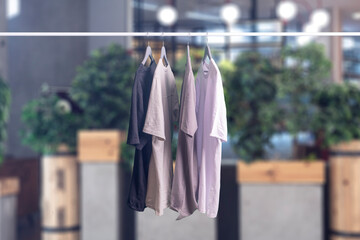 some new t - shirts collection hang on the hanger rack, sale and retail concept