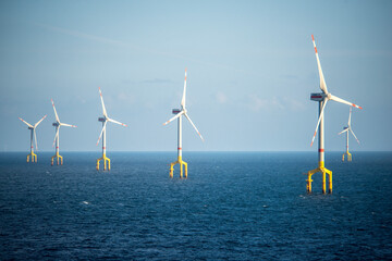 Offshore wind farm turbines at dusk in the middle of the sea
