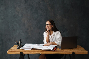 Smiling mid aged brunette woman architect working