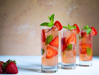 Three glasses of strawberry mojito with mint on the white background