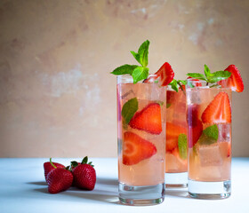 Three glasses of strawberry mojito with mint on the white background
