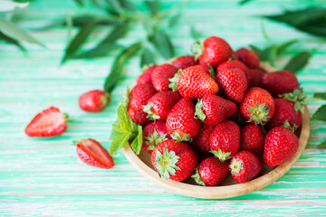 Fresh red strawberries in a plate on a rustic background, seasonal summer berries, selective focus