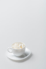 sugar cubes in cup with saucer on white
