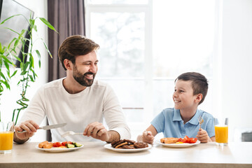 Fototapeta na wymiar Happy father and his son having breakfast
