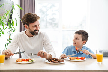 Happy father and his son having breakfast - Powered by Adobe