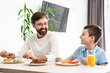 Happy father and his son having breakfast