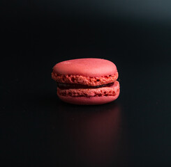 Colorful pink macaron on a black background. Clipping path, isolated