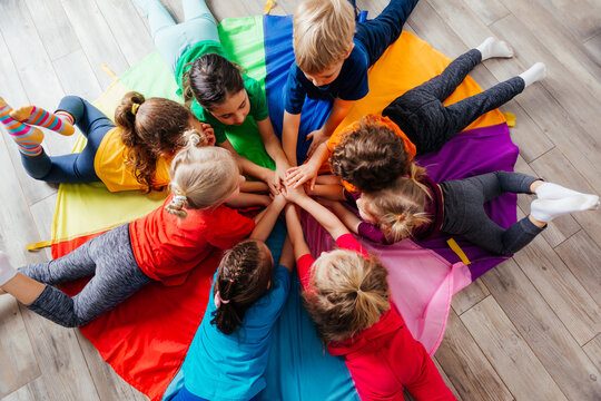 Happy Kids Laying On A Floor In Circle