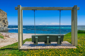 Bench with view on the beach and the ocean at the North Cove beach of Perc&eacute;, the famous Perc&eacute; rock in Gaspesie, Quebec (Canada)