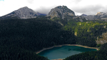 Naklejka na ściany i meble Aerial view a bewitching view of a mountain lake with forest