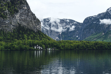 Naklejka na ściany i meble Hallstatt, Austria. Beautiful spring lake surrounded by high mountains. Clear lake on a background of alpine mountains in the fog.