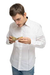 Young handsome tall slim white man with brown hair looking at two tea cups in white shirt isolated on white background