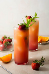 Pink lemonade with fresh strawberries, orange fruit and mint. Fresh summer fruit cocktails.