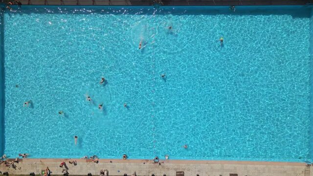 overhead view of public city pool at sunny hot day people swimming