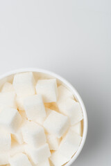 top view of sugar cubes in cup on white