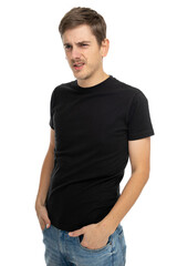 Young handsome tall slim white man with brown hair is confused with hands in pockets in black shirt isolated on white background