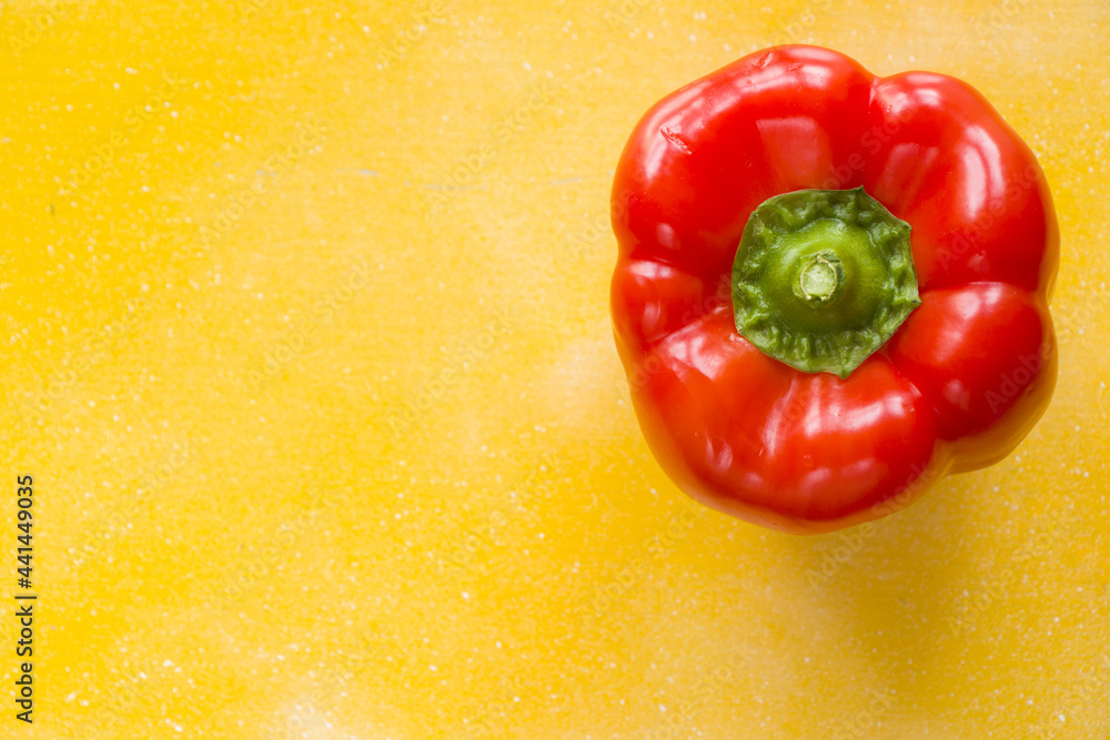 Wall mural Top view of a red bell pepper isolated on yellow background for a copy space