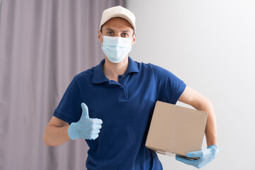 Man from delivery service in t-shirt, in protective mask and gloves giving food order and holding boxes over white background.