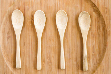Top view of four empty wooden spoons on the wooden plate
