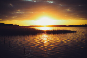 Fototapeta na wymiar Yellow sunset on the lake. Blurred natural background, Sunset sky over lake