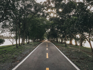 Fototapeta premium Road in the park. Walking path and bike trail with people exercise at Nong Bon Water Sports Center. Bangkok, Thailand