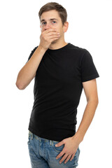 Fototapeta premium Young handsome tall slim white man with brown hair holding his mouth in black shirt in blue jeans isolated on white background