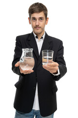 Young handsome tall slim white man with brown hair showing glass pitcher of water and glass of water isolated on white background