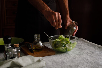a man is preparing a vegetable salad. Adds spices