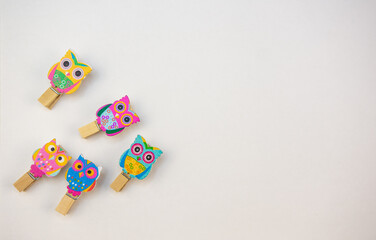 five wooden owl pegs on a white background