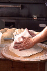 a guy making pizza shaping the dough