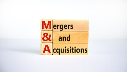 Mergers and acquisitions symbol. Concept words 'M and A, Mergers and acquisitions' on wooden blocks on a beautiful white background. Business and Mergers and acquisitions concept.