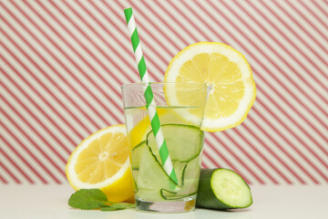 Lemon cucumber water with colorful paper straw. Healthy detox drink.	