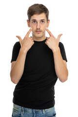 Young handsome tall slim white man with brown hair pointing at his face in black shirt in blue jeans isolated on white background