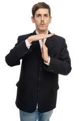 Young handsome tall slim white man with brown hair making pause sign with his hands in black blazer isolated on white background