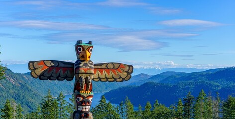 Totem pole towers over scenic wilderness and ocean - obrazy, fototapety, plakaty