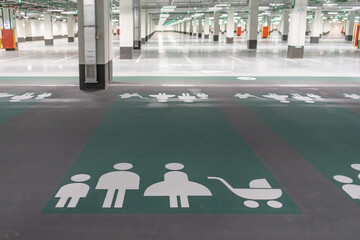 Huge parking space and a sign on the floor of the underground carpark - places for families with children.