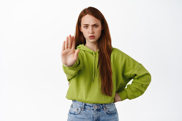Stop. Angry ginger girl stretch hand to prohibit, reject and disapprove, decline something, say no,...