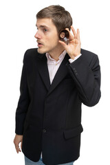 Young handsome tall slim white man with brown hair holding wooden ring in front of his ear in black blazer isolated on white background