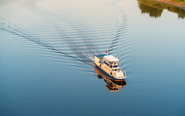 Evening. A small passenger ship sails on the river