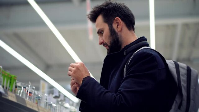 Shopping In Hypermarket Mall On Electronic Device Store Section.Man In Market Choosing Led Lamp. Businessman In Supermarket.Bayer Guy Choose Lamp For Home. Customer Looking On Product In Consumer Shop