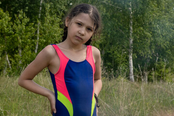 Girl in swimsuit in nature. Outdoors, day light Front view.