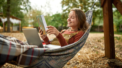 young woman is reading her notes while lies in a hammock 