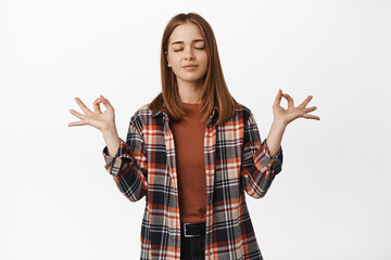 Staying calm. Young girl student close eyes, meditating, peace yoga gesture, holding hands in zen...