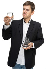 Young handsome tall slim white man with brown hair is disappointed about glass of water in black blazer isolated on white background