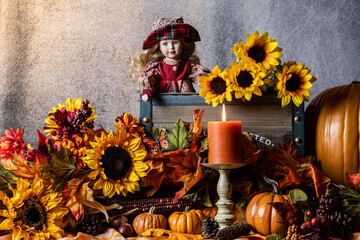 fall scene with orange pumpkins yellow sunflowers burning candle and young girl doll