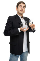 Young handsome tall slim white man with brown hair with glass pitcher of water and a glass of water isolated on white background