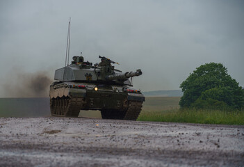 Action shot of a British army Challenger 2 FV4034 Main Battle Tank on a military exercise, lights on at dusk, Salisbury Plain, UK  © Martin