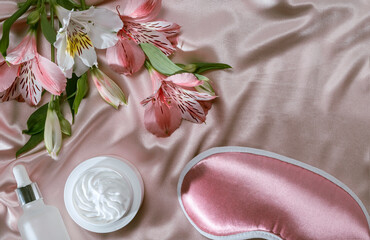daily skincare before bedtime, moisturizer or nourishing cream, serum and sleep mask on a silk background