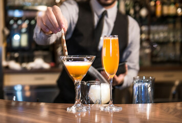 Bartender stirring, squeezing lemon/lime and preparing cocktails and alcoholic beverages in Vancouver restaurant 